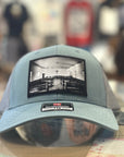 Smoke Blue Richardson Hat with a church patch on it on a blur store background