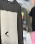 Black sweatshirt with a black and white patch featuring a surfer debating to go out into the water.