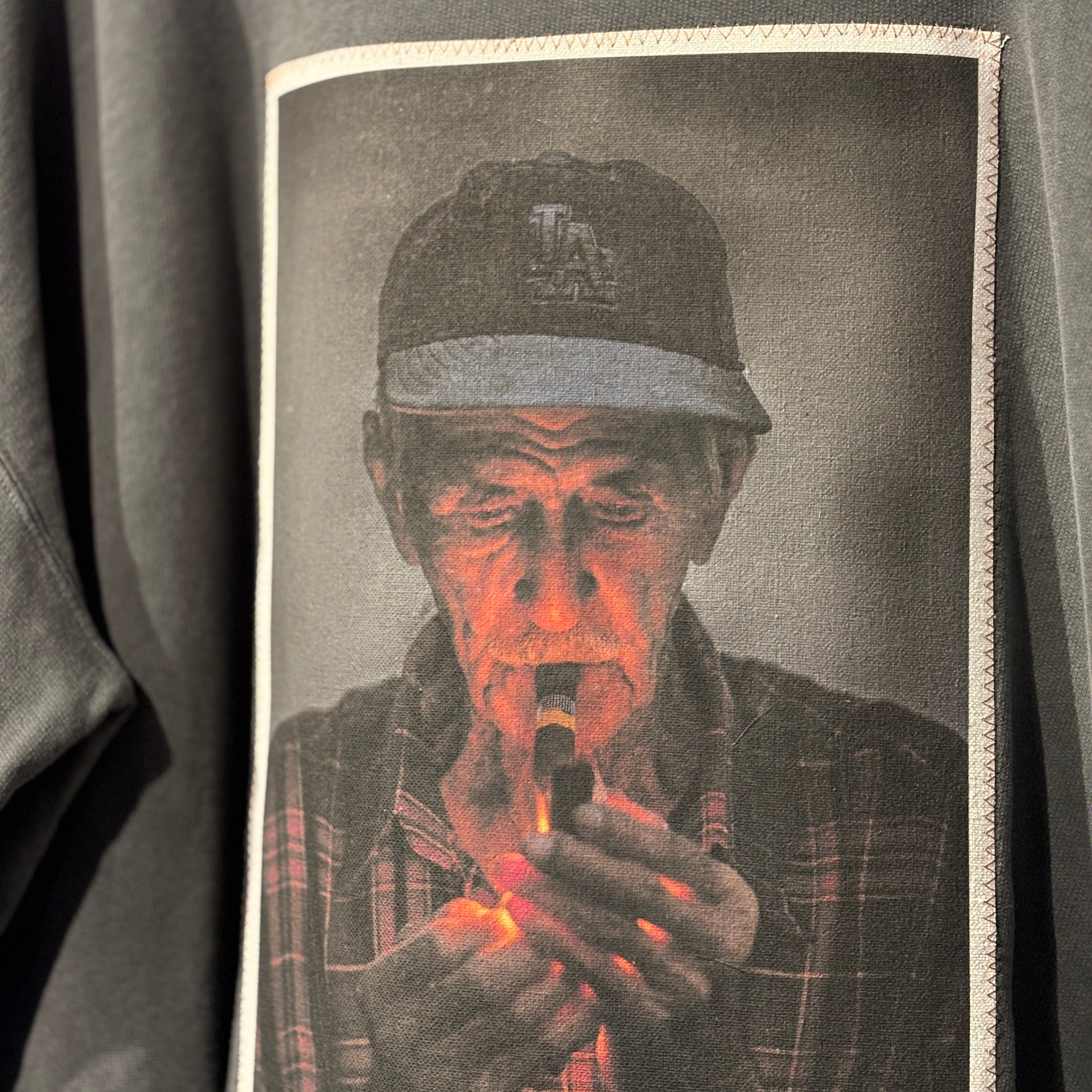 Sweatshirt with a graphic of a man holding a lit match against a dark background