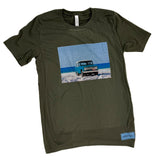 Green t-shirt with a graphic of a truck on a beach landscape