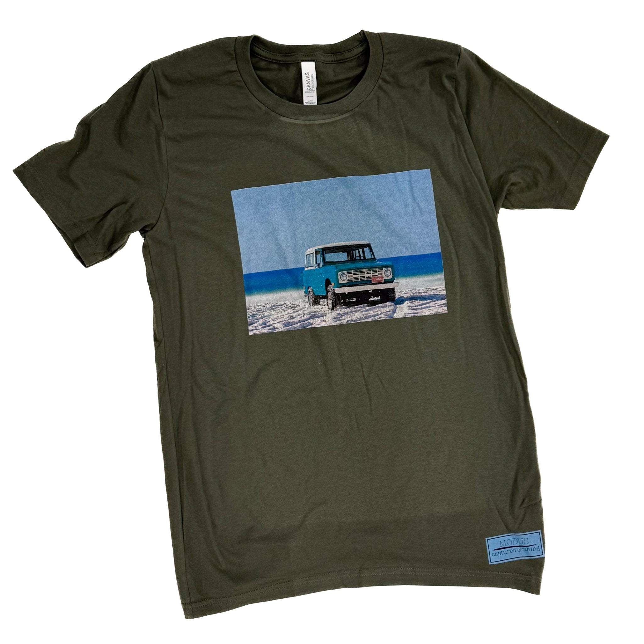 Green t-shirt with a graphic of a truck on a beach landscape