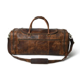 Brown leather duffel bag with a strap on a white background