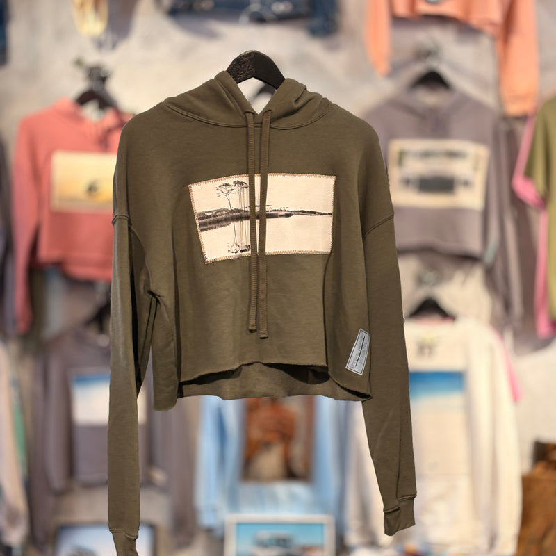 Cropped hoodie with a western lake design on a blurry store background 