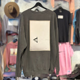 Gray sweatshirt with a graphic design on a hanger against a clothing store background