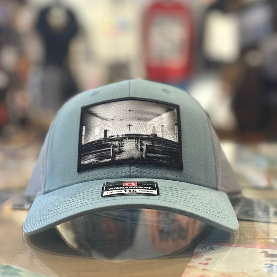 Smoke Blue Richardson Hat with a church patch on it on a blur store background