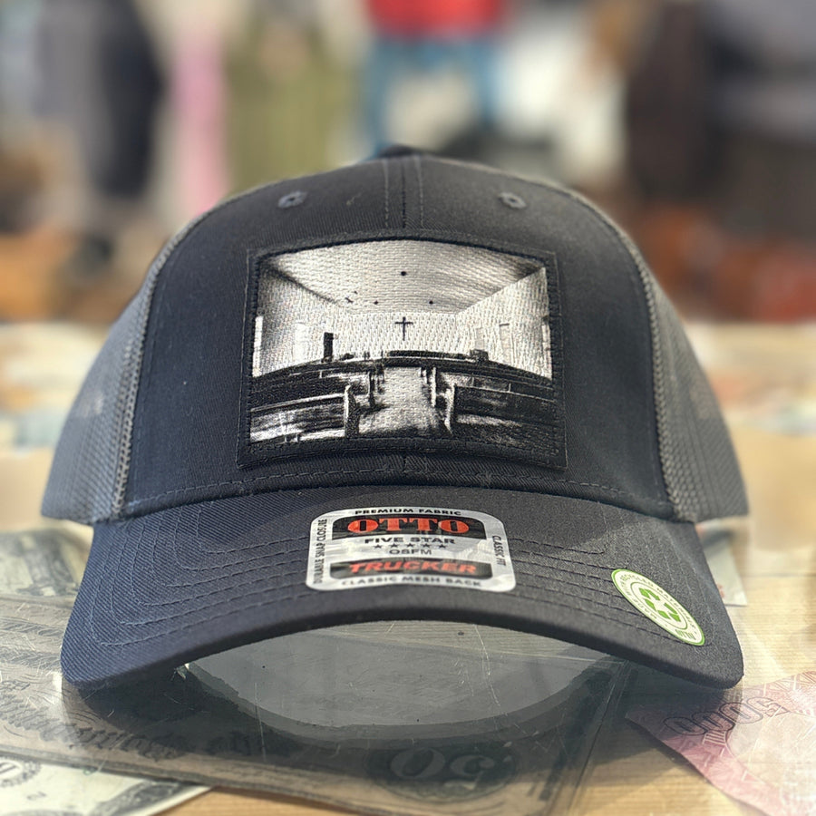 Black cap with a printed  church design on a blurred background