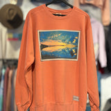 Orange sweatshirt with a graphic design of a sunset over water, hanging on a rack with other clothing in the background.