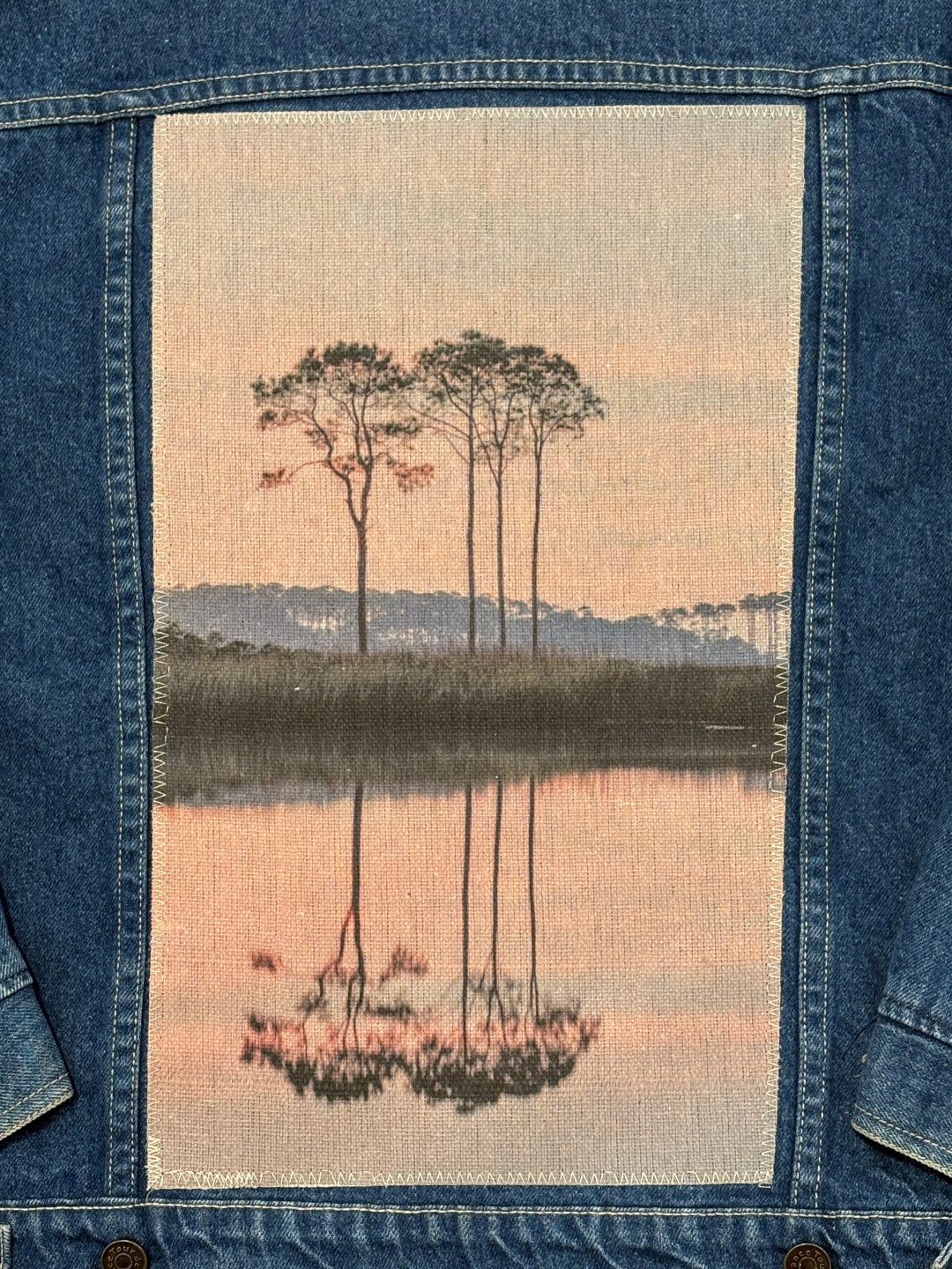 Embroidered design of western lake on a denim fabric