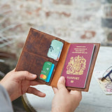 Brown leather wallet with cards and a passport held by a person against a blurred background