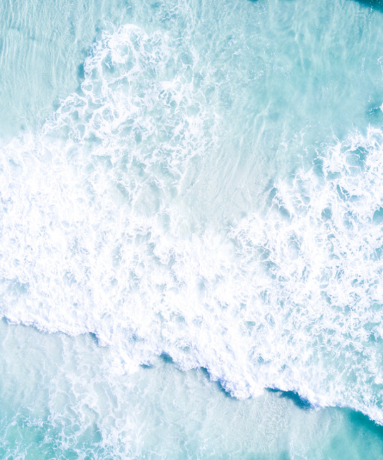 Aerial photo of turquoise waves breaking over white sand at Grayton Beach, Florida.