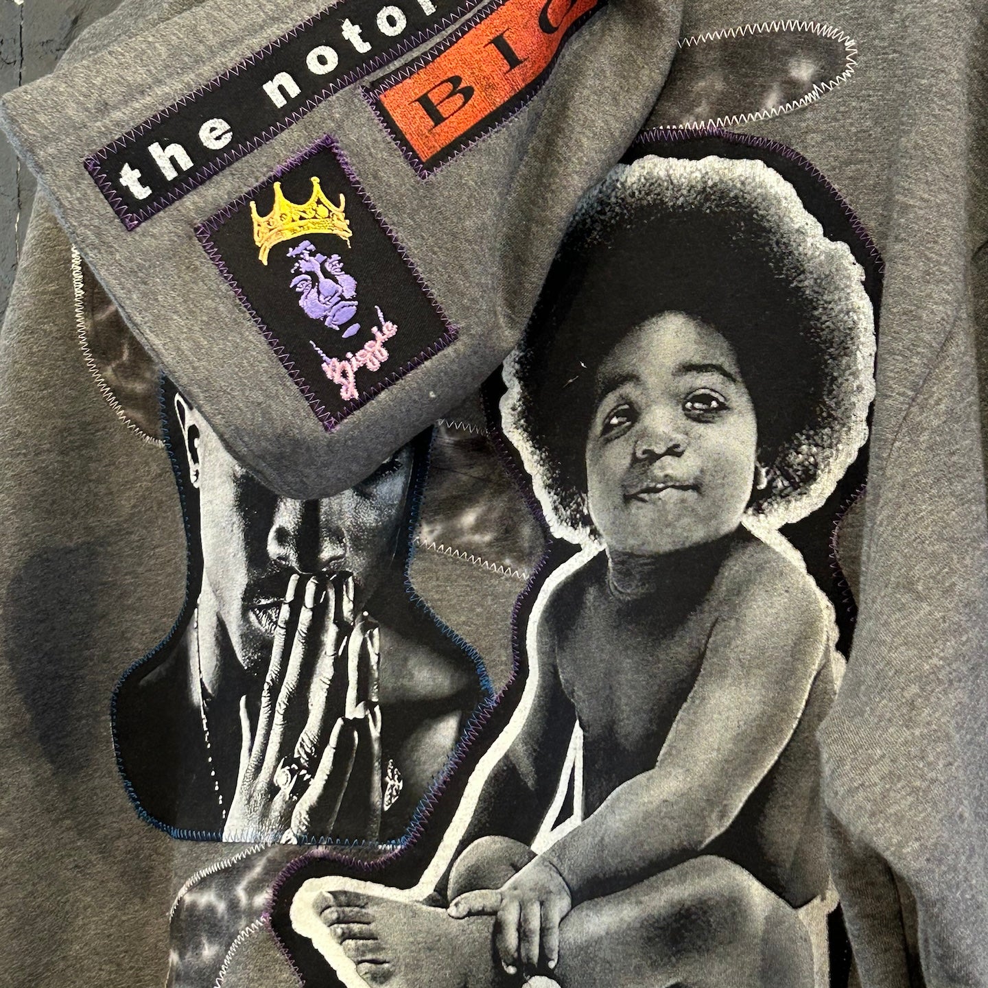 Gray sweatshirt with patches including 'the notorious B.I.G.' and a black and white photo of a child.