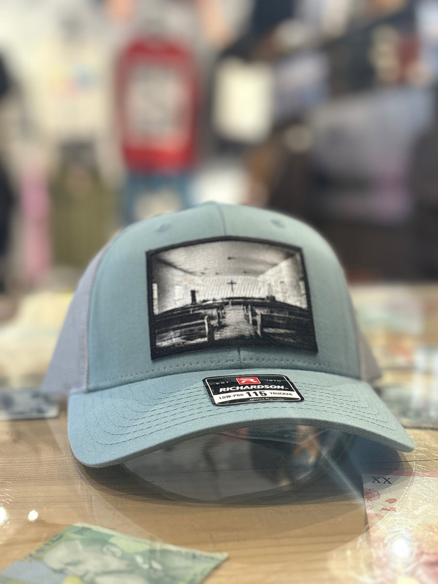 smoke blue hat with a church patch on it 