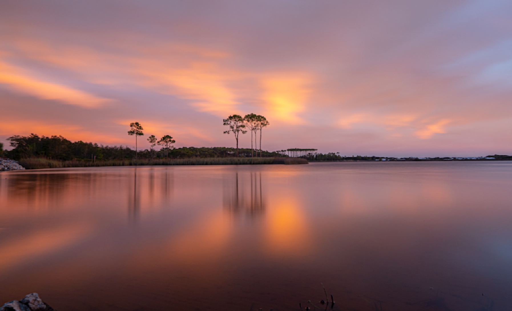 Sunset photograph of Western Lake with longleaf pine reflections and orange-pink sky, Grayton Beach Florida.